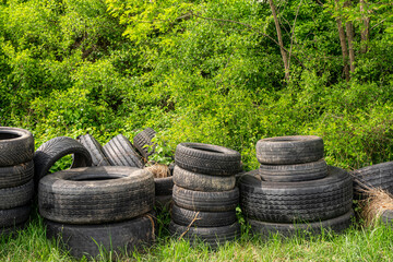 Used car tires thrown into the forest. Environmental pollution concept
