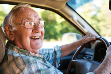 Smiling elderly man driving a car on a sunny day, enjoying the ride and looking happy.