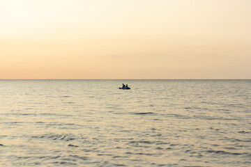 Fototapeta premium Riding a canoe on the sea during a sunset