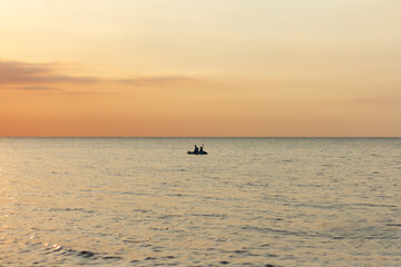 Riding a canoe on the sea during a sunset