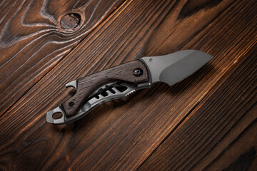 Tactical knife on a wooden background