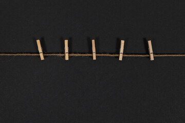 wooden clothespins on rope on dark background