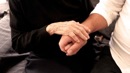 Hugs of an old hundred-year-old woman and the young hands of an adult son, symbolizing support,...