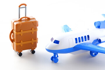 離陸を待つ飛行機とスーツケース（キャリーケース）で、これから旅行に出発するイメージ
