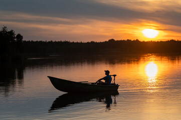 Man Rowing Boat on Lake at Sunset