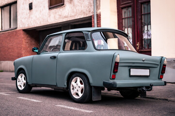 An old vintage car is parking on the street. Oldtimer vehicle. Rear view of the tail lights.