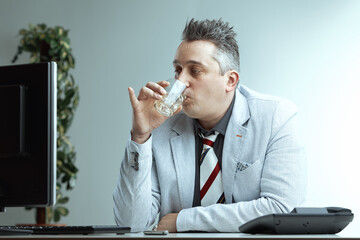 Man in suit drinks alcohol, feels normal