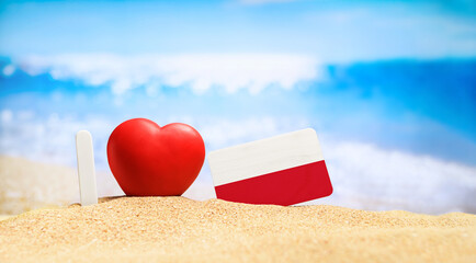 I love Poland. Flag of Poland on the beach with a red heart. vacation and travel concept.