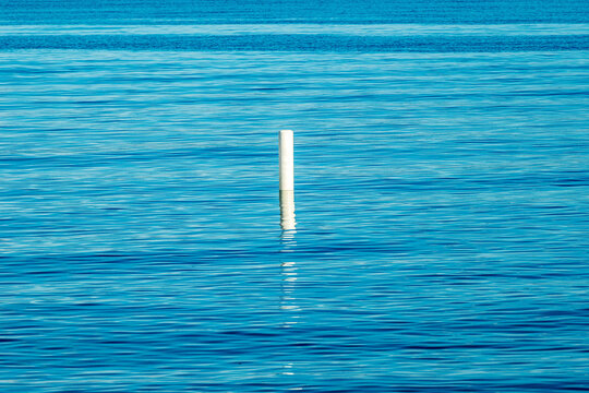 Calm evening on the beach blue smooth water with white safety bouy shot kew beach toronto spring time room for text