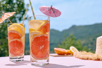 Summer refreshing lemonade drink with grapefruit, lemon and orange slices. Fresh healthy cold citrus beverage. Citrus fruit infused water.