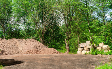 Duze bloki granitowie na placu budowy. Sklad budowlany pod lasem. Przygotowanie do budowy. Matarialy budowlane na swiezym powietrzu. © ff25