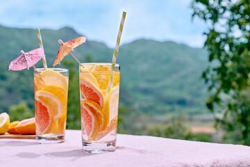 Summer refreshing lemonade drink with grapefruit, lemon and orange slices. Fresh healthy cold citrus beverage. Citrus fruit infused water.