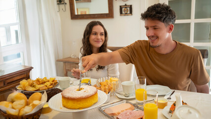 família em casa sentada a mesa pra tomar café da manhã, reunião de família, família feliz comendo. mesa de café da manha com frutas e pão.