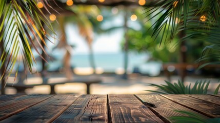 Empty wooden table top for product display, presentation stage. Tropical summer, palm trees, beach bar, white sand and blue ocean in the background. 