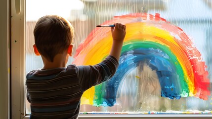 little boy paints window pane