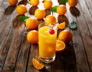 Orange juice and fresh fruits on an old wooden table.