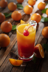 Classic tequila sunrise cocktail on an old wooden table.