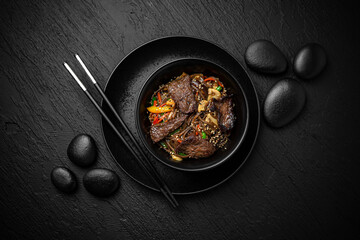 Wok soba with beef and vegetables. Composition on black background. The Art of Japanese Cuisine. Food photography for menu and sushi bar decoration