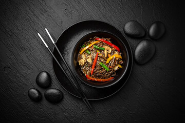 Wok soba with vegetables. Composition on black background. The Art of Japanese Cuisine. Food photography for menu and sushi bar decoration