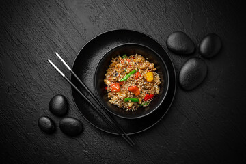 Wok rice with vegetables. Composition on black background. The Art of Japanese Cuisine. Food photography for menu and sushi bar decoration