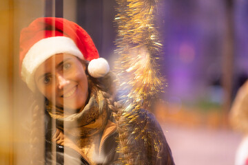junge attraktive Frau beim shoppen auf dem Weihnachtsmarkt, Lichterglanz und weihnachtliche...