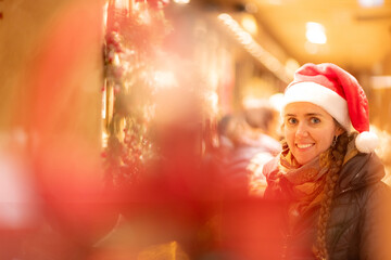 junge attraktive Frau beim shoppen auf dem Weihnachtsmarkt, Lichterglanz und weihnachtliche...