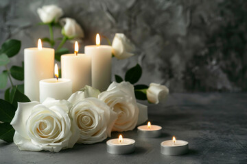 A touching condolence background featuring lit candles and elegant white roses on a somber grey surface for memorial occasions