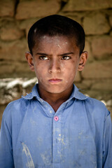 poor hopeless Asian boy with dirty clothes and face with angry eyes