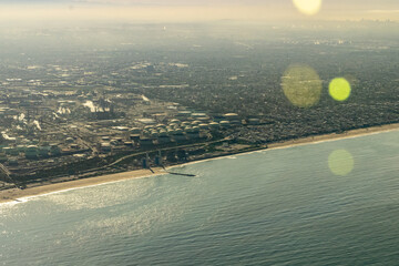 Aerial view of the California Coastline over the Pacific Ocean looking in at El Segundo, the beach, and the Oil refinery