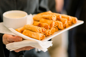 Fried egg rolls served with dipping sauce at an event