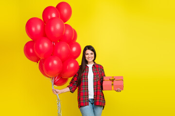 Photo of shiny attractive lady dressed checkered shirt holding birthday gifts empty space isolated yellow color background