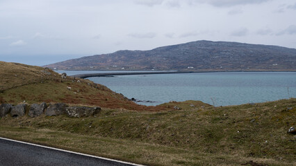 Scenic view overlooking ocean and causeway connecting the islands of Eriskay and South Uist in the...