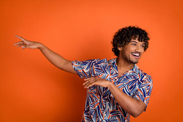 Photo portrait of attractive young man dancing have fun dressed stylish colorful clothes isolated on orange color background