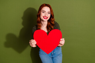 Photo of adorable pretty lady wear shirt holding large paper heart empty space isolated khaki color background