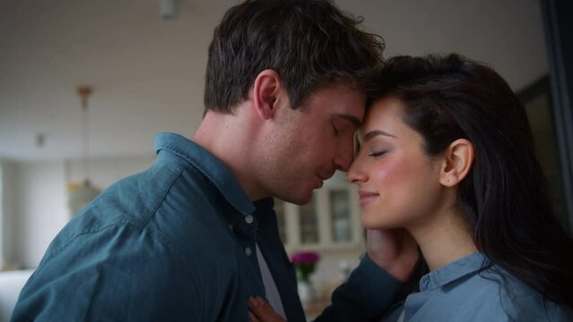 Caucasian happy couple touching forehead talking man boyfriend guy male propose engagement marry me surprise showing box wedding ring family woman girl female girlfriend say yes agree hugging at home