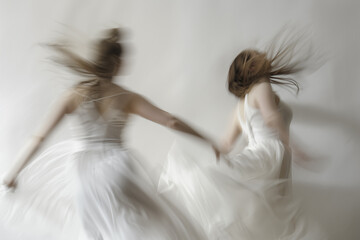 Women dancing contemporary ballet  on a white background captured with motion blur.