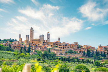Medieval San Gimignano hill town with skyline of medieval towers, including the stone Torre Grossa....