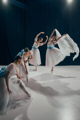 Dynamic portrait of elegant quartet of ballet dancers, each in unique pose, wearing white tutus and...