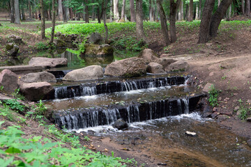 A small artificial waterfall on a stream in a city park. Minsk, Belarus