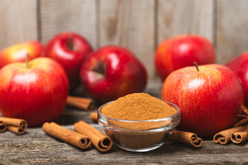 Apples with cinnamon on a textured wooden background. Fragrant red spiced apples with cinnamon...