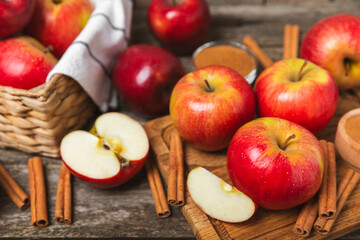 Apples with cinnamon on a textured wooden background. Fragrant red spiced apples with cinnamon sticks and star anise. Apple slices with spicy spices. Place for text. Copy space. Harvesting. Fruits. 