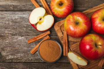 Apples with cinnamon on a textured wooden background. Fragrant red spiced apples with cinnamon...