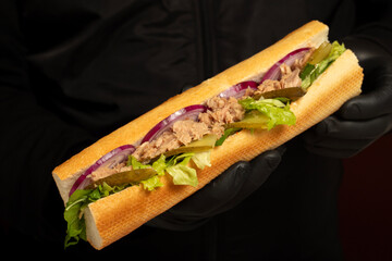 Tuna sandwich made with tuna meat, special sauce, purple onion, pickles and greens