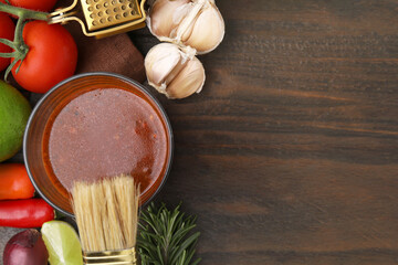 Tasty marinade and products on wooden table, flat lay. Space for text