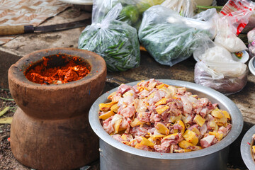Fresh chicken meat put in a pot and red chili pound. For making various curries.