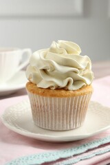 Tasty cupcake with vanilla cream on table, closeup