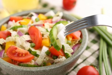 Eating delicious salad with Chinese cabbage at table, closeup