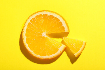 Slices of juicy orange on yellow background, top view