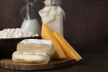 Dairy products. Different kinds of cheese and milk on wooden table, space for text
