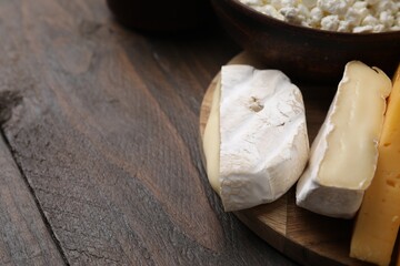 Dairy products. Different kinds of cheese on wooden table, closeup. Space for text